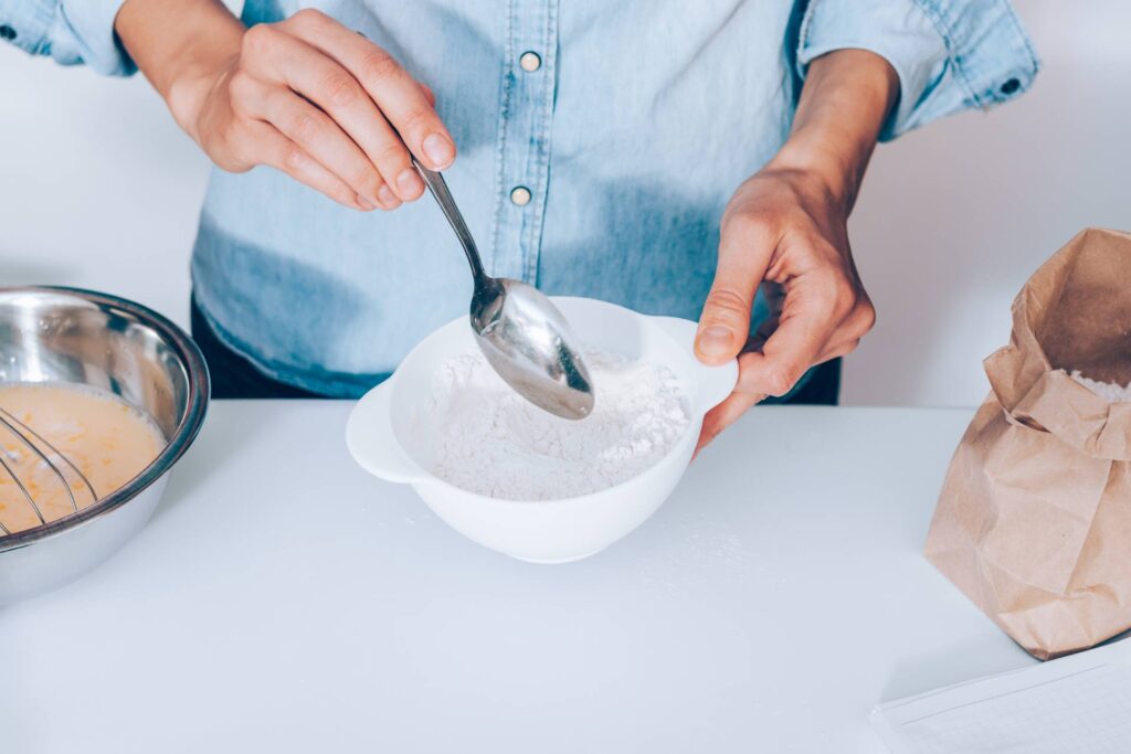 Young woman mixing flour to make dough